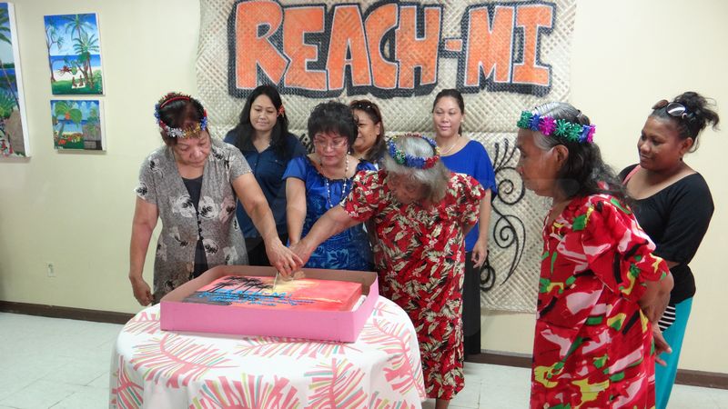 Nuclear test survivors Maria Capital, left, and Lemeyo Abon, right, join REACH-MI president Rosania Bennett to cut a cake at the launch in Majuro of the new nuclear justice organization. Photo by Giff Johnson