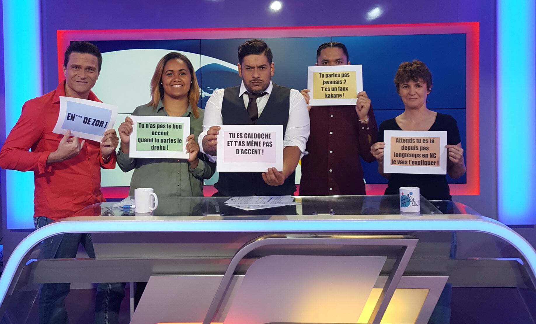 Figure 36: The presenters and participants of the TV show ‘#lelien’ share linguistic their micro-aggressions. Translations of the transcripts they are holding (from left to right) 1) ‘****(insult) ‘ZOR’ (comes from ‘zoreille’, slang for ‘white’) 2) ‘You don't have the right accent when you speak drehu’ 3) ‘You're Caldoche and you don't even have the accent!’ (‘Caldoche’ is slang for native-born European, French settlers and their descendants established in NC) 4) ‘You don't speak Javanese? You're a fake “kakane”!’ 5) ‘Wait a sec, you’ve been in NC for how long? Let me teach you how it works…’